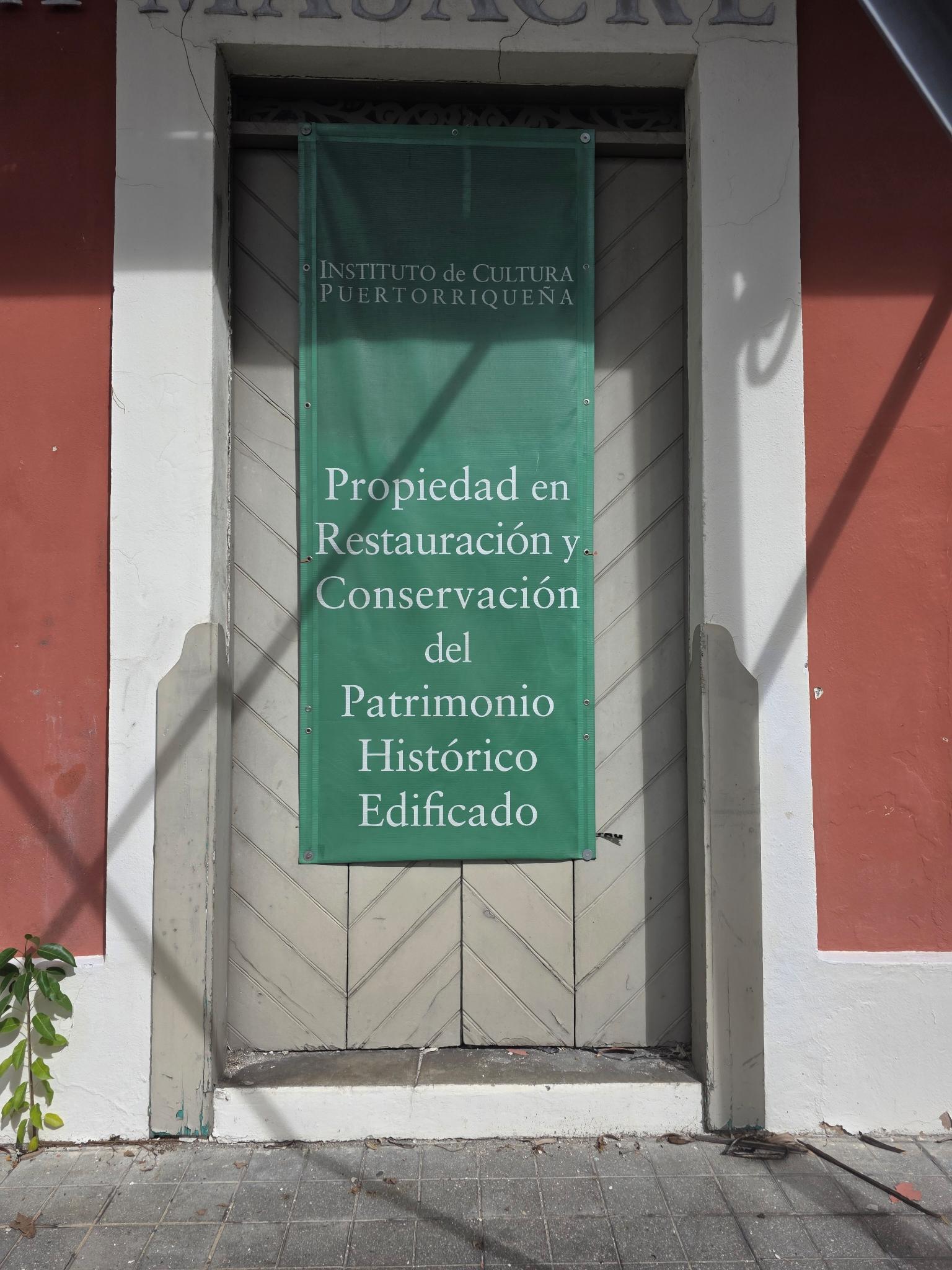 Museum door with restoration banner, boarded shut
